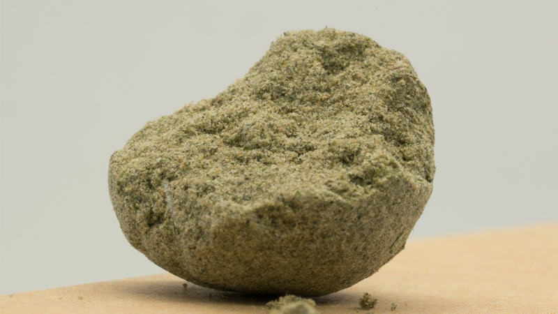 Geformter Block aus Kief auf heller Unterlage. Rohmaterial zur Herstellung von Haschisch.